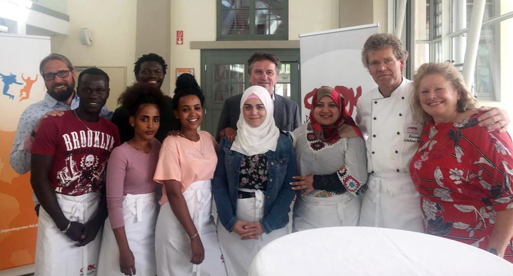 Gruppenfoto von Minister Manne Lucha und Auszubildenden des Projekts „Cook Your Future“ in Heidelberg