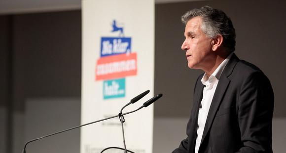 Integration Erster Landesfachtag Migrantenorganisationen in Stuttgart Sami Aras, erster Vorstandsvorsitzender des Forums der Kulturen, steht an Redepult vor Publikum
