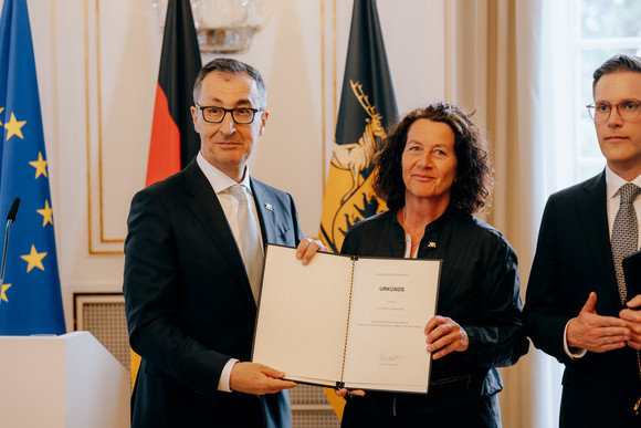 Ministerpräsident Cem Özdemir hält gemeinsam mit Staatssekretärin Petra Krebs deren Ernennungsurkunde.