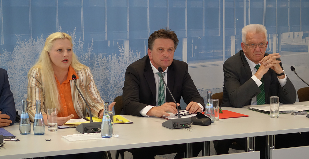 Stephanie Aeffner, Manne Lucha und Winfried Kretschmann auf dem Podium der Regierungspressekonferenz in Stuttgart
