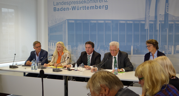 Blick auf das mit Stephanie Aeffner, Manne Lucha und Winfried Kretschmann besetzte Podium der Regierungspressekonferenz