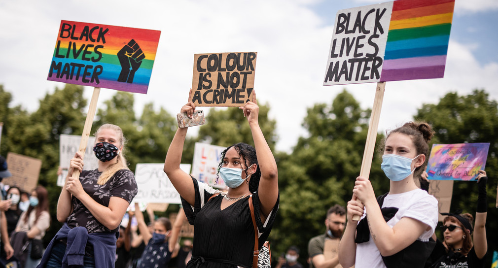 Junge Frauen mit Schildern auf einer Demonstration gegen Rassismus