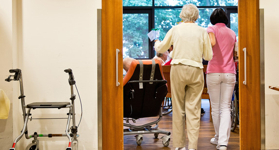 Eine auf Demenzkranke spezialisierte Pflegerin begleitet eine ältere Frau.