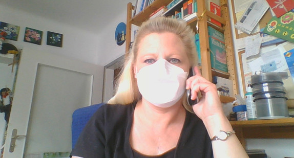 Landes-Behindertenbeauftragte Stephanie Aeffner mit Atemschutzmaske beim Telefonieren