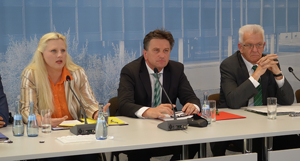 Stephanie Aeffner, Manne Lucha und Winfried Kretschmann auf dem Podium der Regierungspressekonferenz in Stuttgart