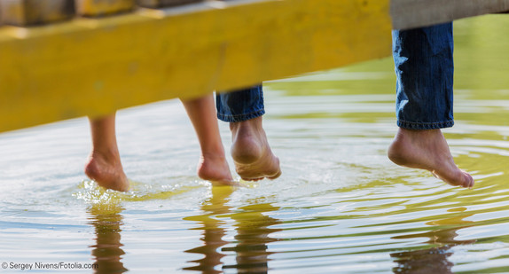 Füsse baumeln über Wasser