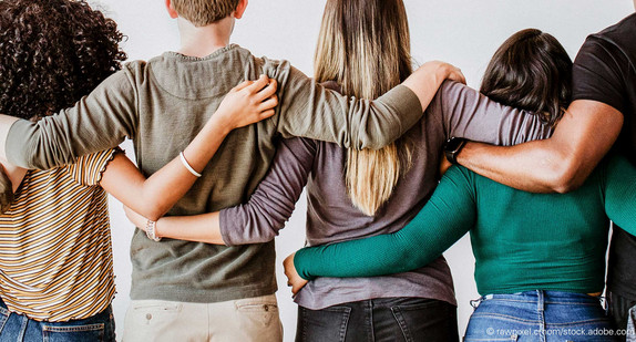 Frauen und Männern stehen in einer Reihe und stützen sich gegenseitig.