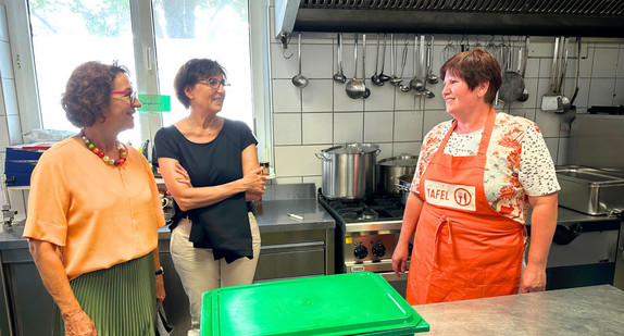 Staatssekretärin Dr. Ute Leidig unterhält sich in der Küche der Tafel in Singen mit Verantwortlichen.