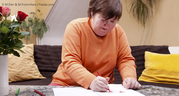 Frau mit Behinderung malt ein Bild