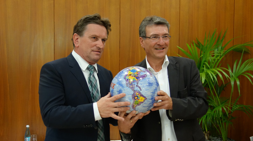 Sozial- und Integrationsminister Manne Lucha und Thüringens Migrationsminister Dieter Lauinger halten eine symbolische Weltkugel