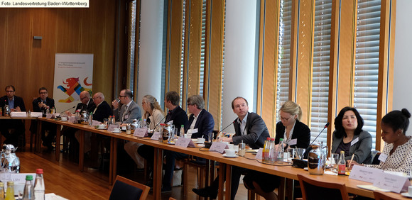 Podiumsdiskussion Bund-Länder-Workshop in Berlin Workshopteilnehmerinnen und -teilnehmer sitzen an Konferenztisch