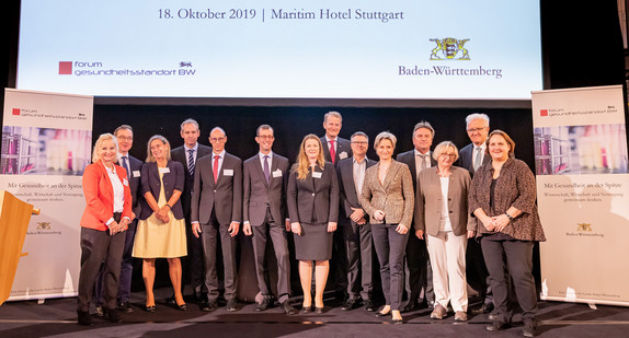 Gruppenfoto auf Veranstaltungsbühne: Ministerpräsident Winfried Kretschmann, Sozial- und Integrationsminister Manne Lucha, Wirtschaftsministerin Dr. Nicole-Hoffmeister-Kraut, Wissenschaftsministerin Theresia Bauer und weitere Referenten zum Forum Gesundheitsstandort BW