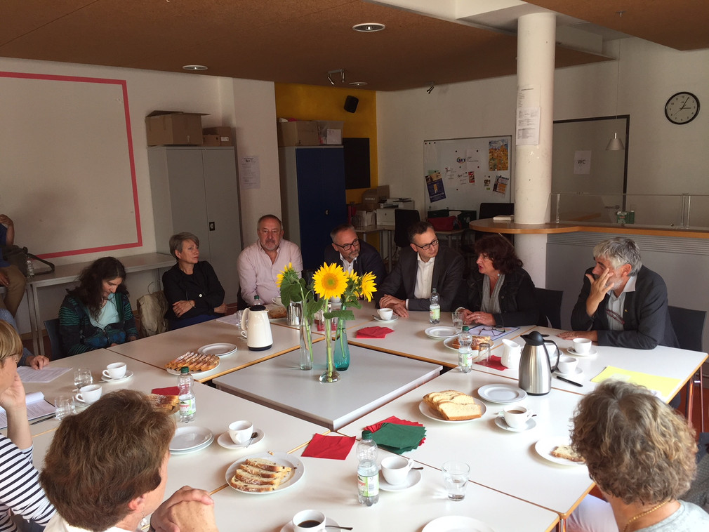 Staatssekretärin Bärbl Mielich sitzt in großer Tischrunde mit Verantwortlichen und Mitarbeitern des Vereins Gemeinsam statt einsam in Kirchheim unter Teck