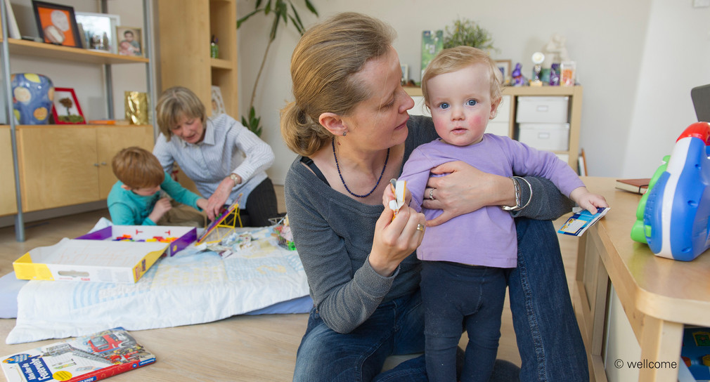 Ehrenamtliche wellcome-Mitarbeiterin betreut Kleinkind bei einer Familie