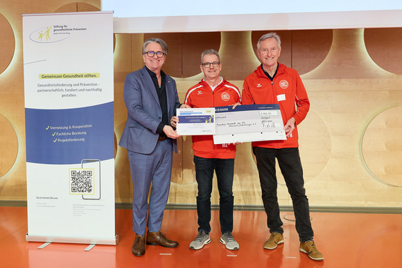Preisverleihung des Präventionspreises: Minister Manne Lucha übergibt Scheck und Urkunde an Preisträger Förderkreis Handball der HG Oftersheim/Schwetzingen, Rhein-Neckar-Kreis.