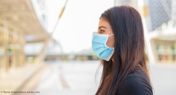 Junge Frau mit medizinischer Maske im Freien