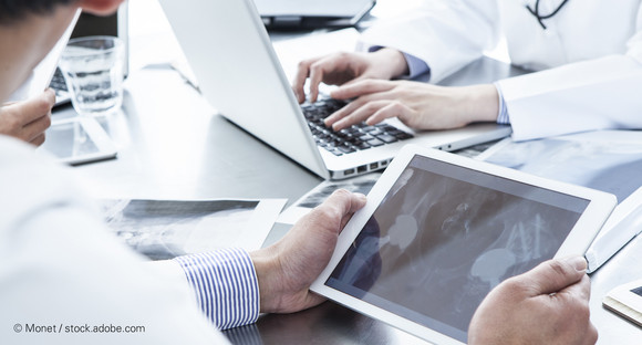 Arzt hält Tablet mit Röntgenbild eines Patienten in der Hand