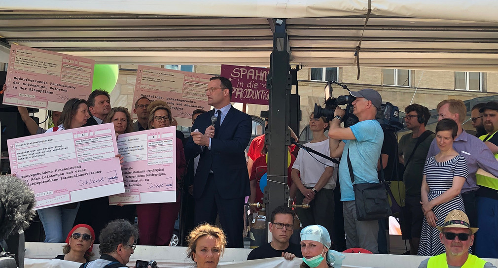 Bundesgesundheitsminister Jens Spahn spricht vor Demonstranten auf einer Bühne mit Baden-Württembergs Gesundheitsminister Manne Lucha im Hintergrund