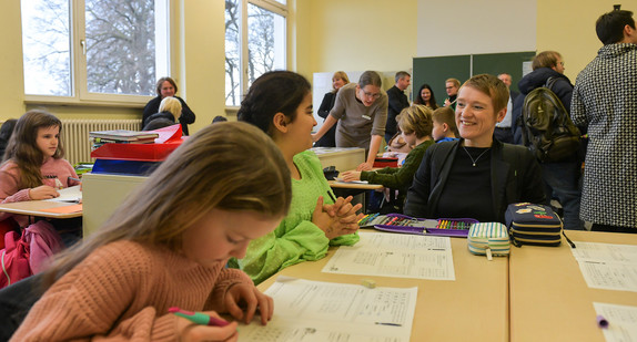 Simone Fischer unterhält sich in einem Klassenzimmer mit einer Schülerin.