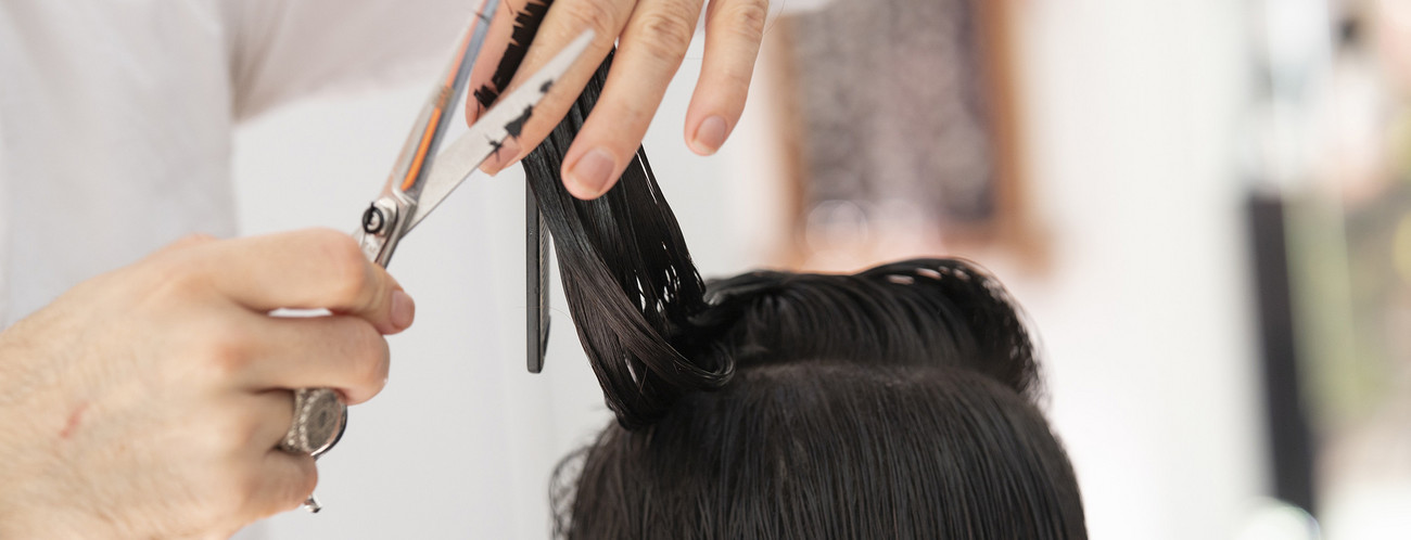 Friseur schneidet Frau die Haare