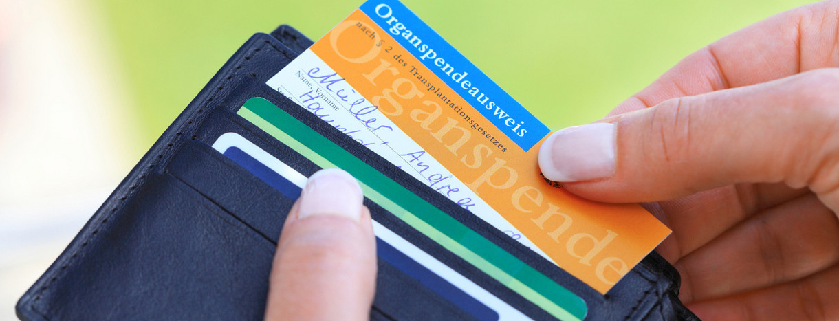 Frau zieht Organspendeausweis aus Portemonnaie