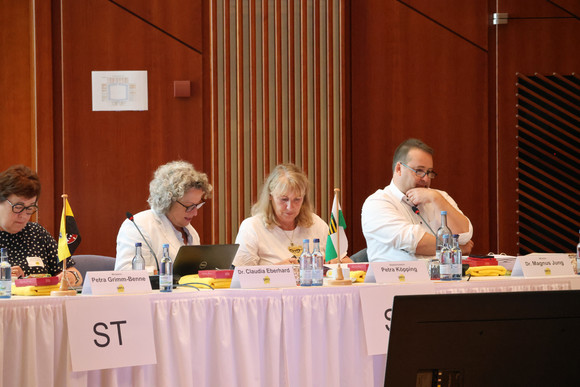 Ministerin Petra Grimm-Benne (Sachsen-Anhalt) und Staatsministerin Petra Köpping (Sachsen) sitzen an Konferenztisch.