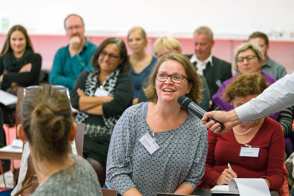 Frau im Publikum stellt eine Frage