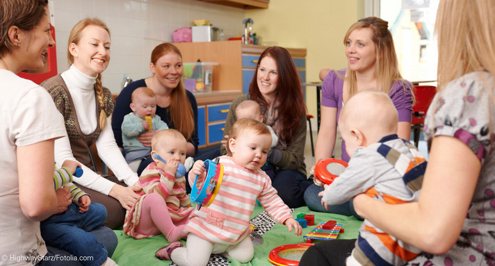 Gruppe von Müttern mit Babies sitzen als Spielgruppe zusammen