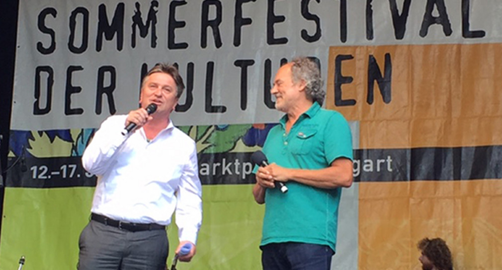 Besuch Sommerfestival der Kulturen Stuttgart Minister Manne Lucha im Gespräch auf einer Bühne