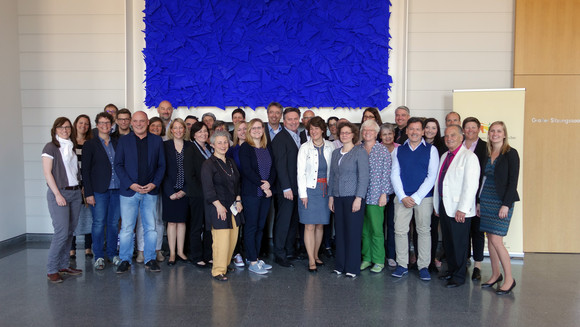 Gruppenfoto der Beiratsteilnehmenden mit Sozial- und Integrationsminister Manne Lucha und Staatssekretärin im Ministerium für Finanzen Gisela Splett vor dem Sitzungssaal im Neuen Schloss Stuttgart