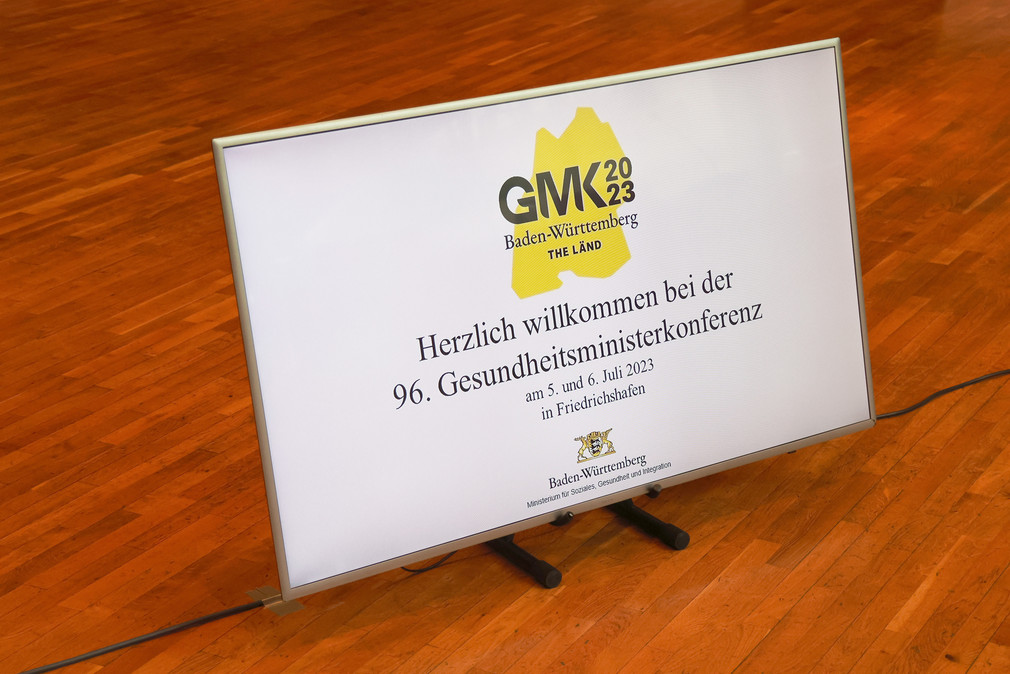 Schild auf Parkettboden mit GMK-Logo und Text: Herzlich willkommen bei der 96. Gesundheitsministerkonferenz