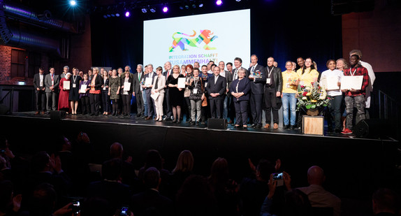 Gruppenbild aller Preisträger des ersten Integrationspreises des Landes Baden-Württemberg auf der Bühne