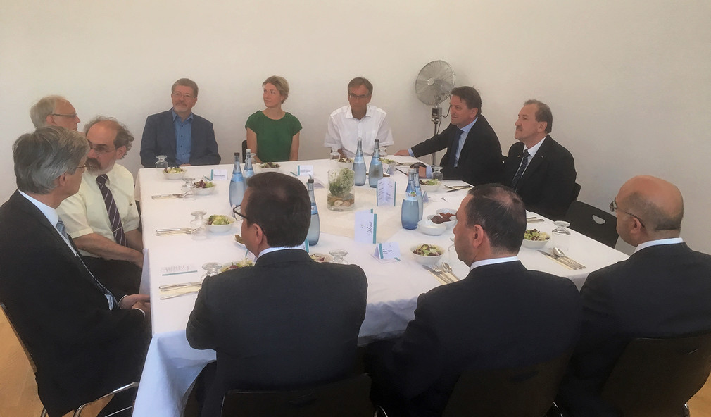 Minister Manne Lucha sitzt gemeinsam mit anderen Teilnehmenden des Iftar-Essens an einem Tisch