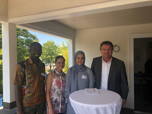 Gruppenfoto mit Abdoulaye Drami aus Mali, Fekrat Misto aus Syrien, Iman Ququil aus Marokko und Minister Manne Lucha