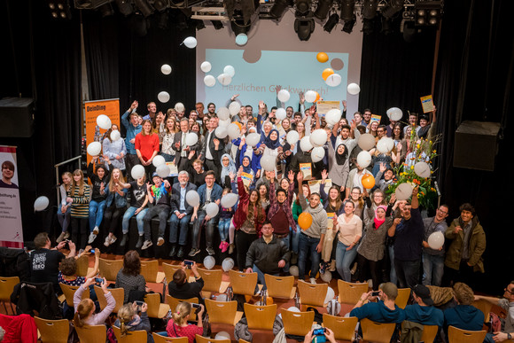 Gruppenfoto aller Preisträger des Jugendbildungspreises DeinDing mit Sozial- und Integrationsminister Manne Lucha auf der Bühne des Stuttgarter Jugendhauses Cann