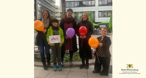 Gruppenfoto von Simone Fischer, Beauftragte der Landesregierung Baden-Württemberg, und Mitgliedern von KiDiS e.V. im Freien in Stuttgart