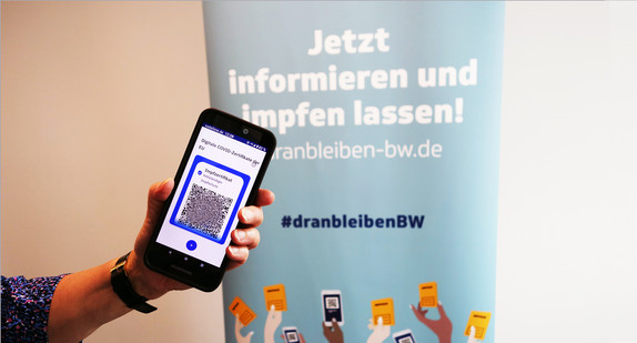 Hand zeigt Handy mit digitalem Impfzertifikat