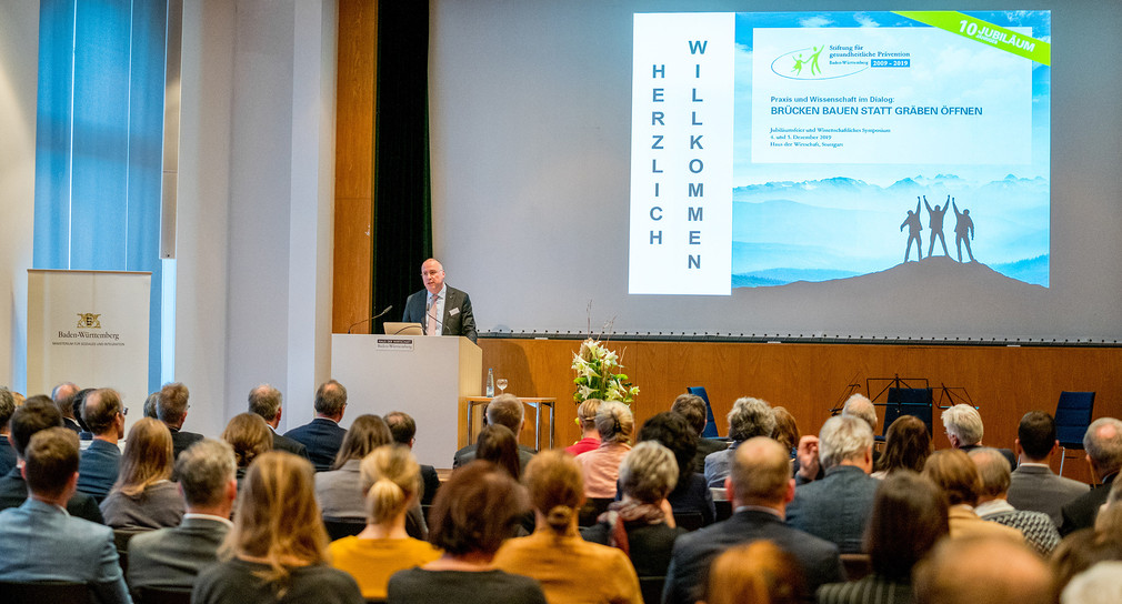 Johannes Bauernfeind, AOK Baden-Württemberg, spricht an Redepult vor Publikum