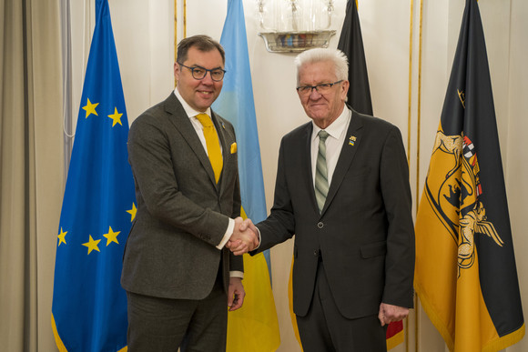 Antrittsbesuch Kretschmann empfängt ukrainischen Botschafter Ministerpräsident Winfried Kretschmann (r.) und der ukrainische Botschafter Oleksii Makeiev (l.) stehen in der Villa Reitzenstein vor Fahnen und geben sich die Hand.
