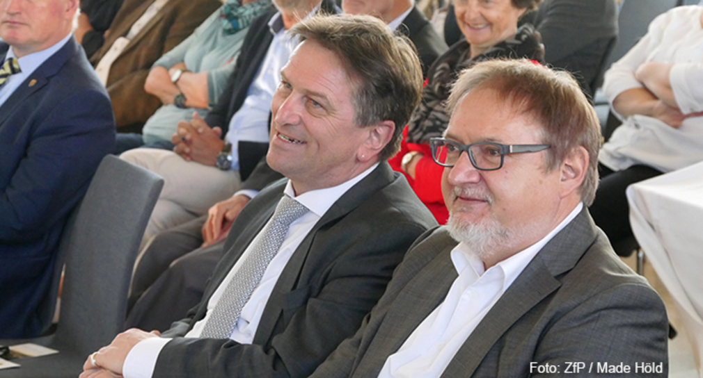 Minister Manne Lucha und Geschäftsführer der ZfP Südwürttemberg Dr. Dieter Grupp hören Vortrag zu