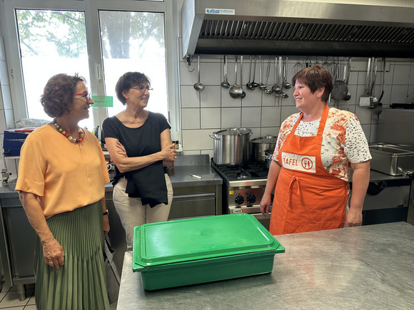 Staatssekretärin Dr. Ute Leidig unterhält sich in der Küche der Tafel in Singen mit Verantwortlichen.