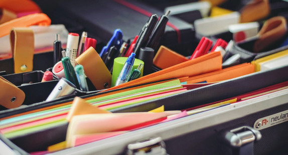 Koffer mit Materialien wie Stiften und farbigen Papierzetteln für Gruppenarbeit