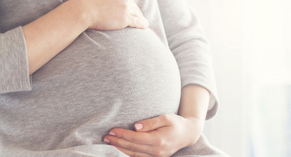 Schwangere Frau hält ihren Bauch