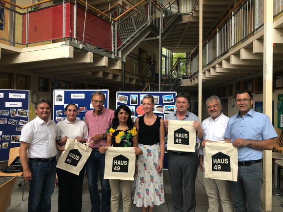 Gruppenfoto bei Besuchs des Internationalen Stadtteilzentrums "Haus 49" im Stuttgarter Norden mit Halil Karaçoban (Förderverein Haus49), Hülya Akbaş (Mutter), Bürgermeister Werner Wölfle, Landtagspräsidentin Muhterem Aras, Korina Smrcek (Leitung), Minister Manne Lucha, Gökay Sofuoğlu (Mitarbeiter Haus 49) und Caritas-Vorstand Uwe Hardt