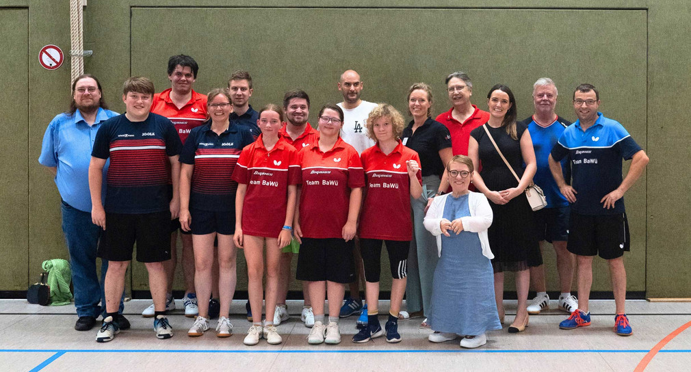 Gruppenbild in der Sporthalle: Minister Dr. Danyal Bayaz und Simone Fischer zusammen mit Ben Büchel und weiteren Tischtennis-Spielerinnen und -Spielern und ihrem Trainerteam, Maren Pilchowski und Harald Laue vom WBRS.