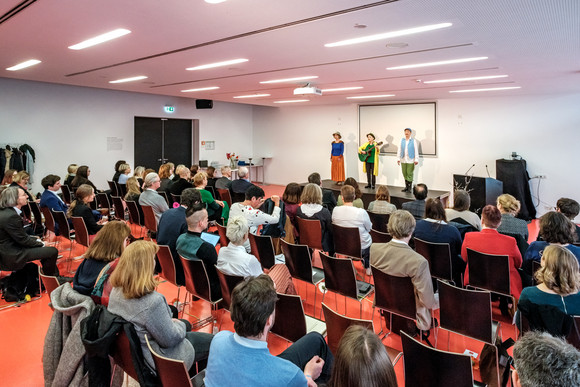 Künstler mit Instrumenten auf der Bühne vor Publikum