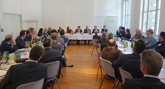 Sozial- und Integrationsminister Manne Lucha und die Teilnehmenden des Runden Tisches der Religionen sitzen am 24. Mai 2017 in Stuttgart an einem Konferenztisch.