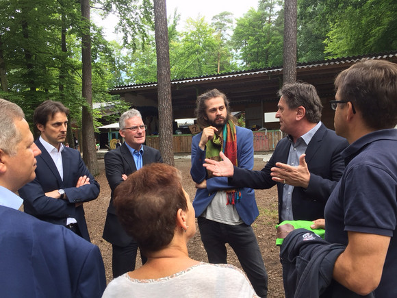 Minister Manne Lucha unterhält sich mit Martin Wuttke (Erster Landesbeamter in Böblingen), Wolfgang Trede (Jugendamtsleiter Böblingen) und Tobias Bacherle (Bundestagskandidat für Bündnis 90/Die Grünen im Wahlkreis Böblingen) auf dem Gelände des Evangelischen Ferienwaldheims Tannenberg.