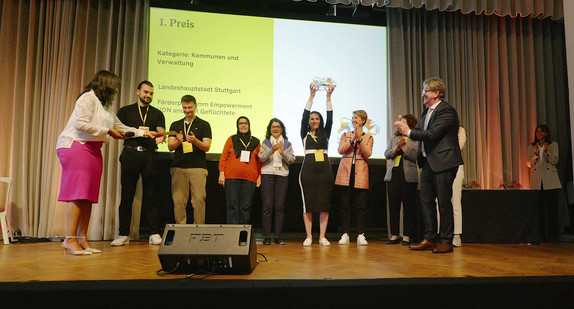 Preisträger werden auf einer Bühne ausgezeichnet. Eine Frau hält einen Award in Form eines Löwen in die Höhe.