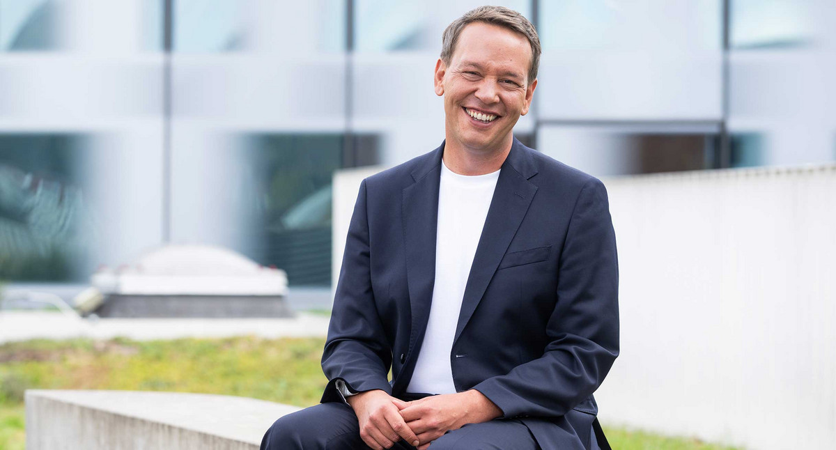 Porträtfoto Oliver Hildenbrand sitzend auf Terrasse des Sozialministeriums Baden-Württemberg